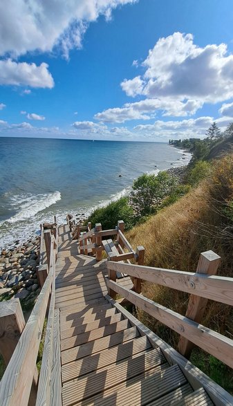 Eine hölzerne Treppe führt die Steilküste hinab ans Meer