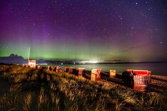 Der Dahmer Strand bei Nacht, am Horizont sieht man Aurora Borealis (Polarlichter) in Grün und Violett